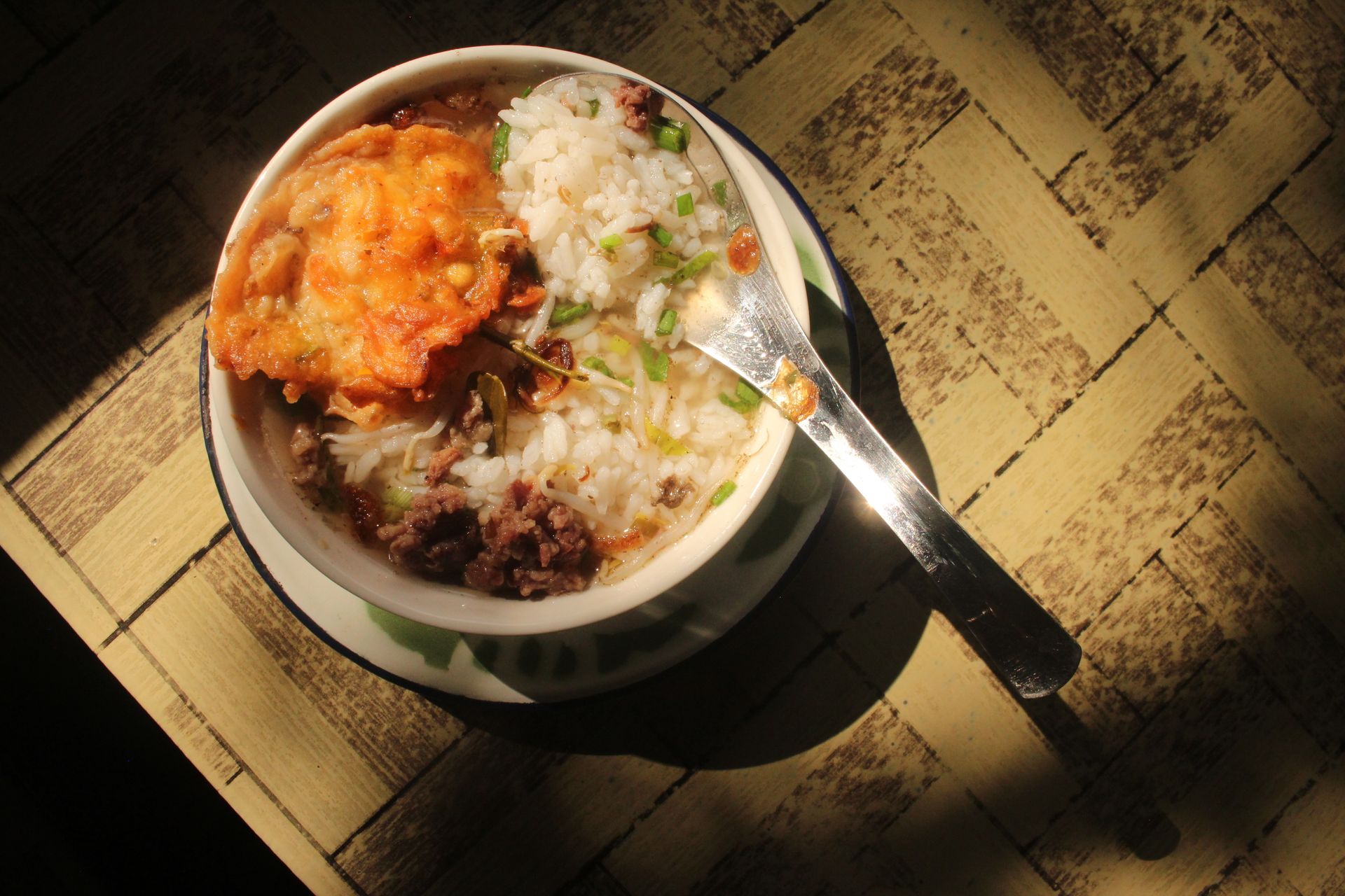 Bowl of rice porridge with meat and egg toppings