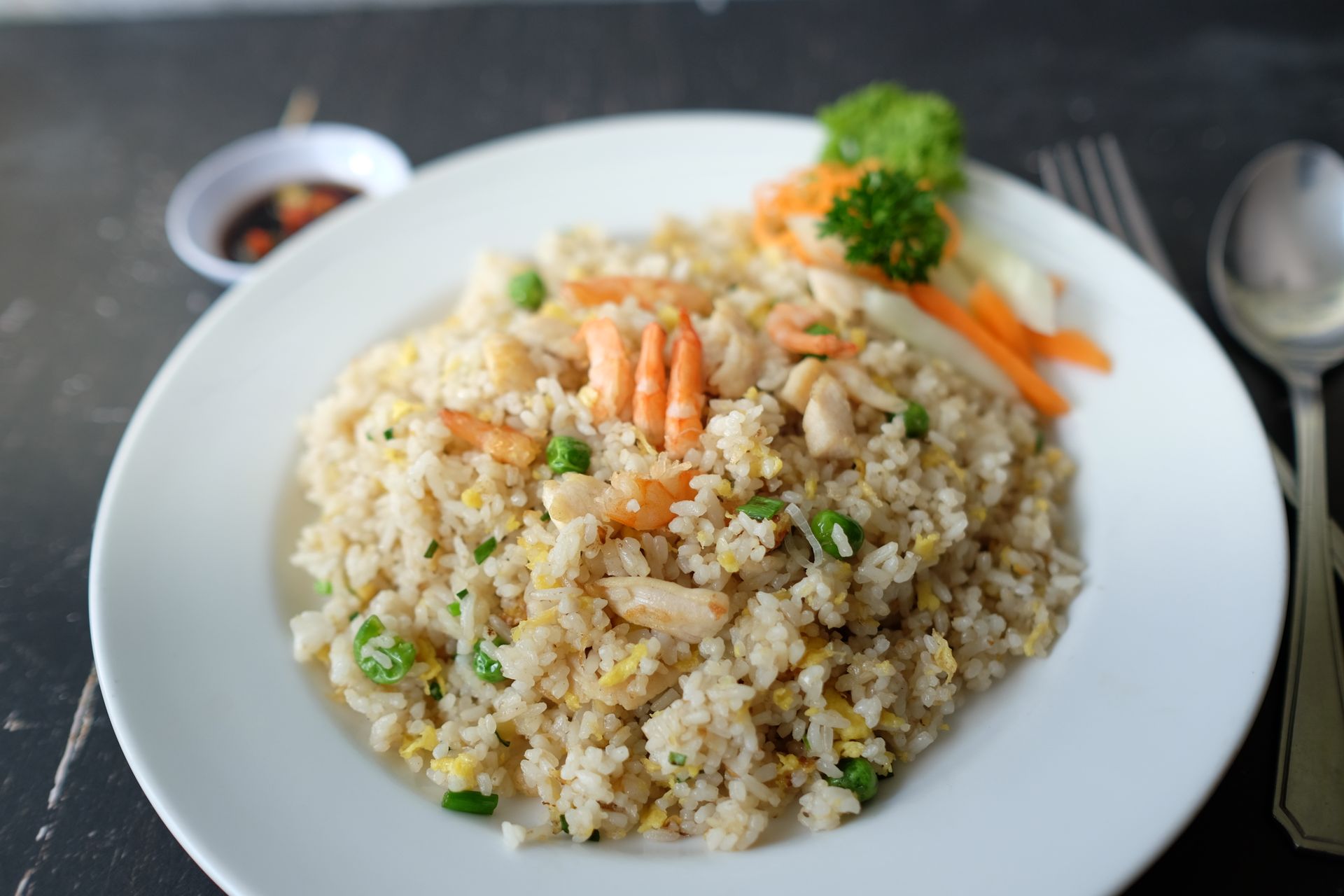 Shrimp fried rice with vegetables on a white plate