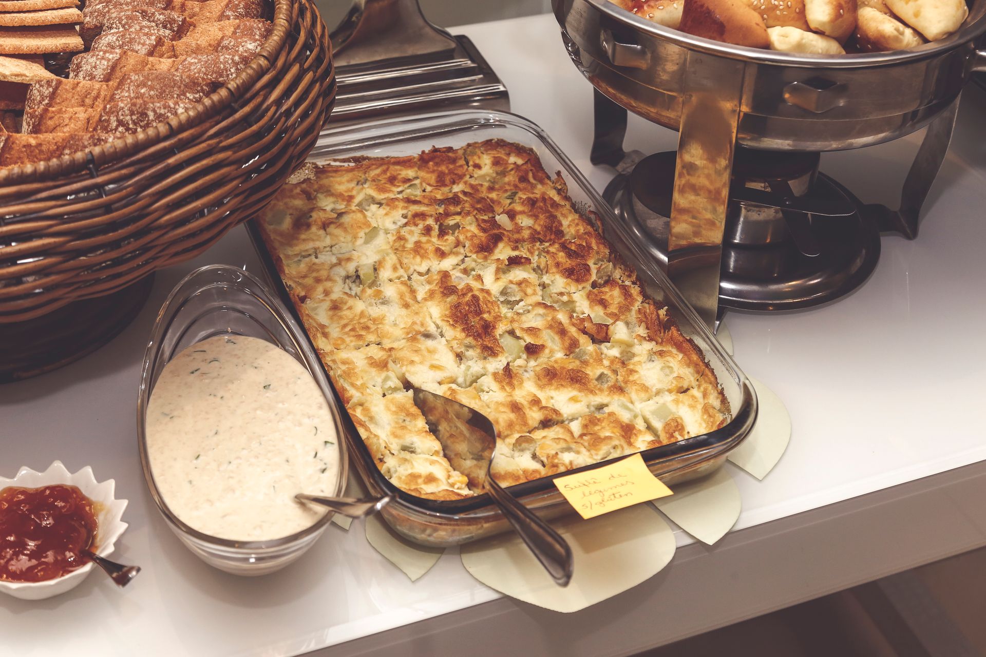 Breakfast casserole in a baking dish with bread on the side