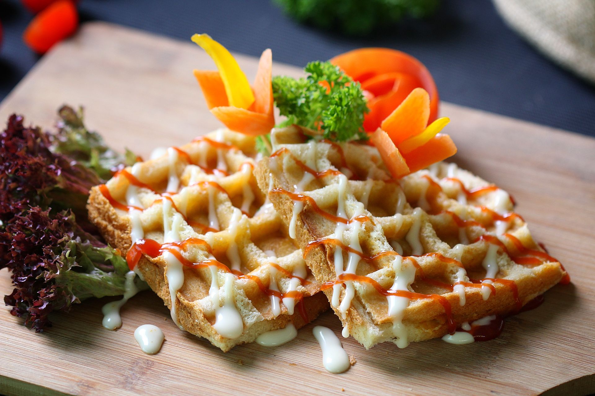 Stuffing waffles drizzled with sauce on a wooden board