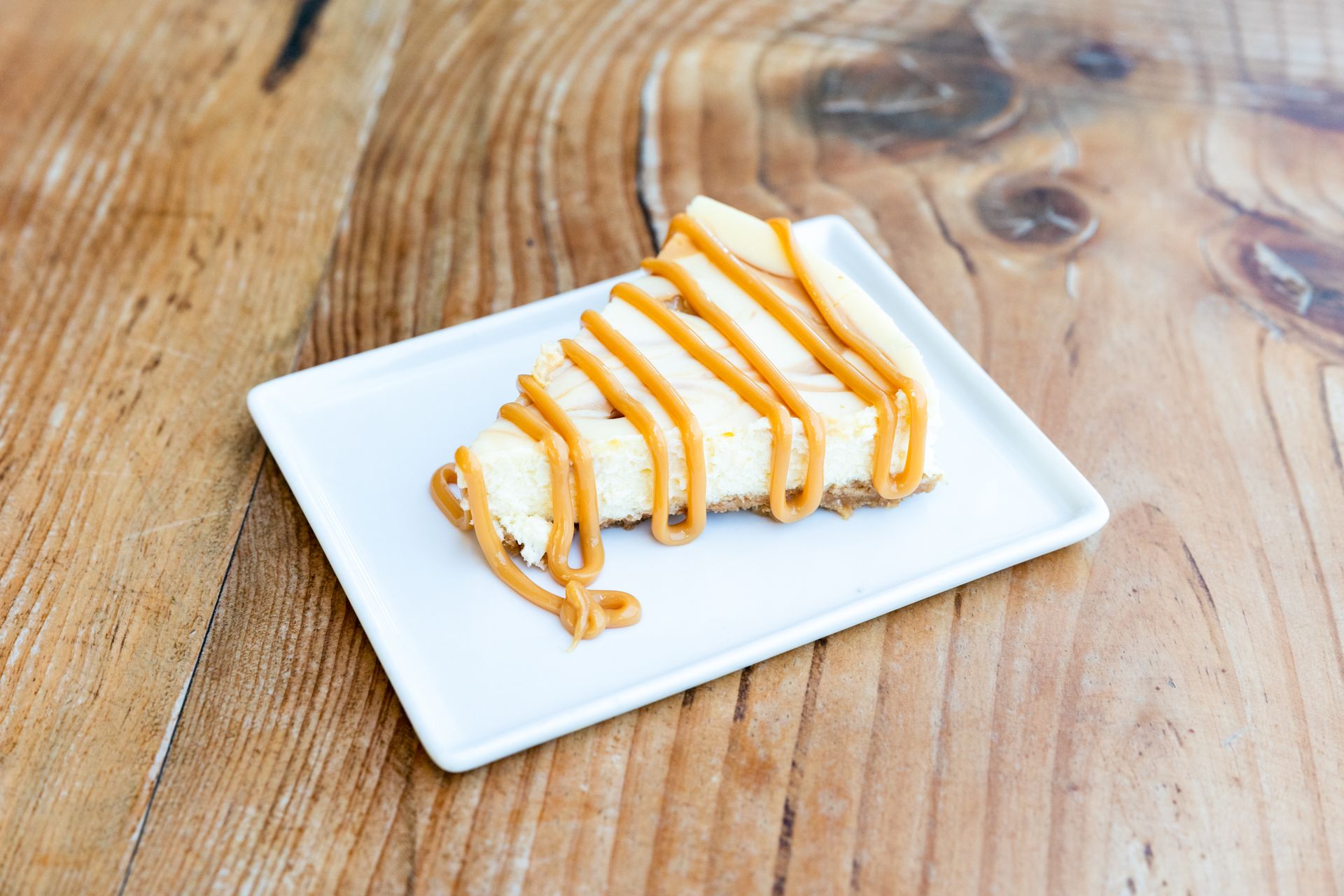 Sticky toffee pudding cheesecake slice drizzled with caramel sauce