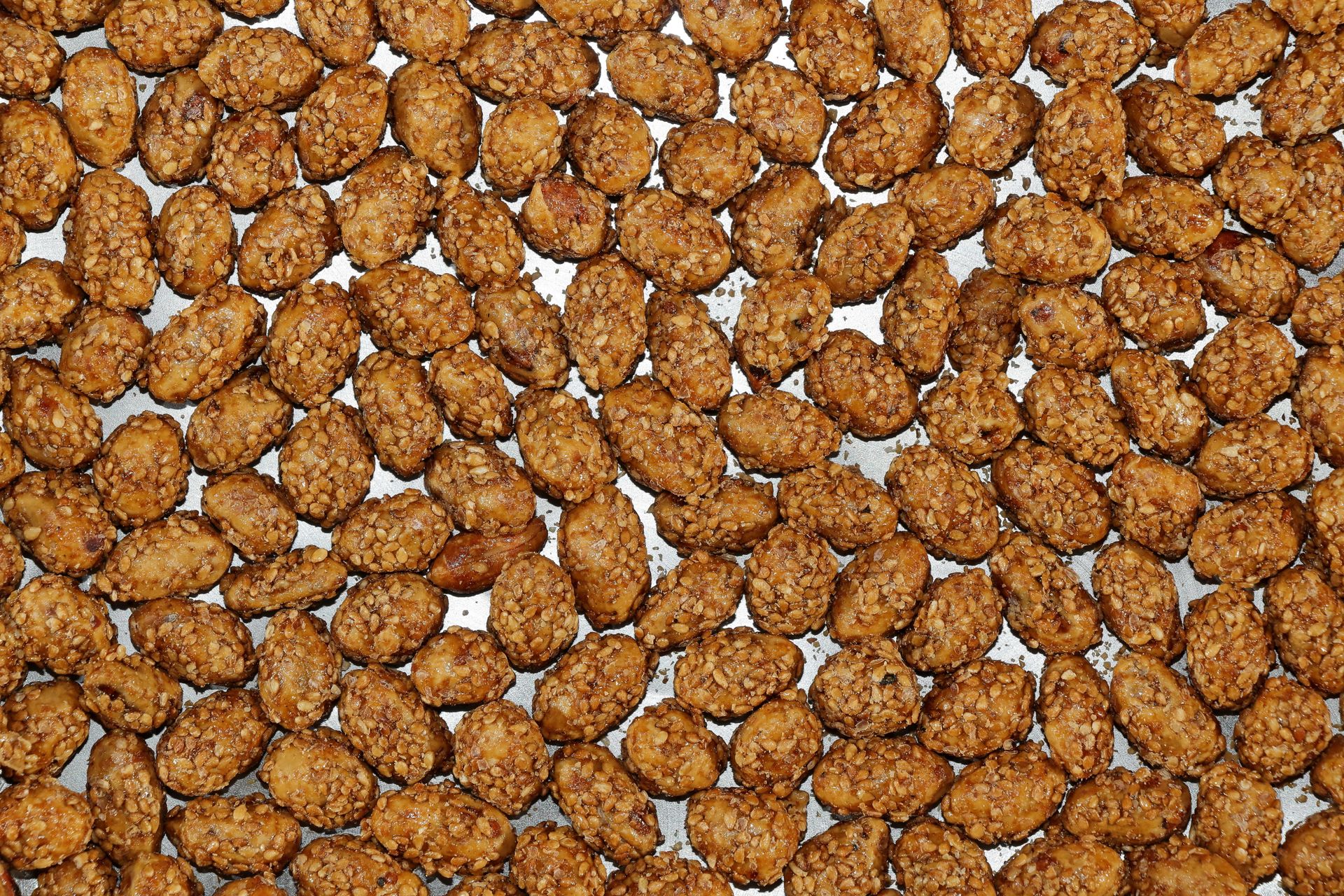Spiced nuts: honey roasted almonds on a baking sheet