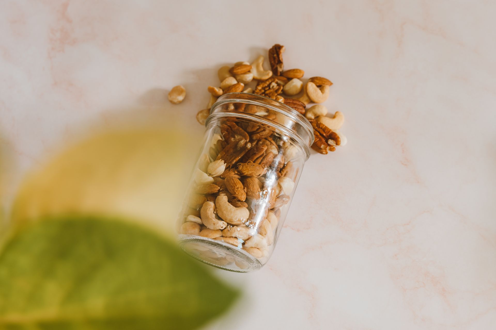 Spiced nuts spilling from a glass gift jar