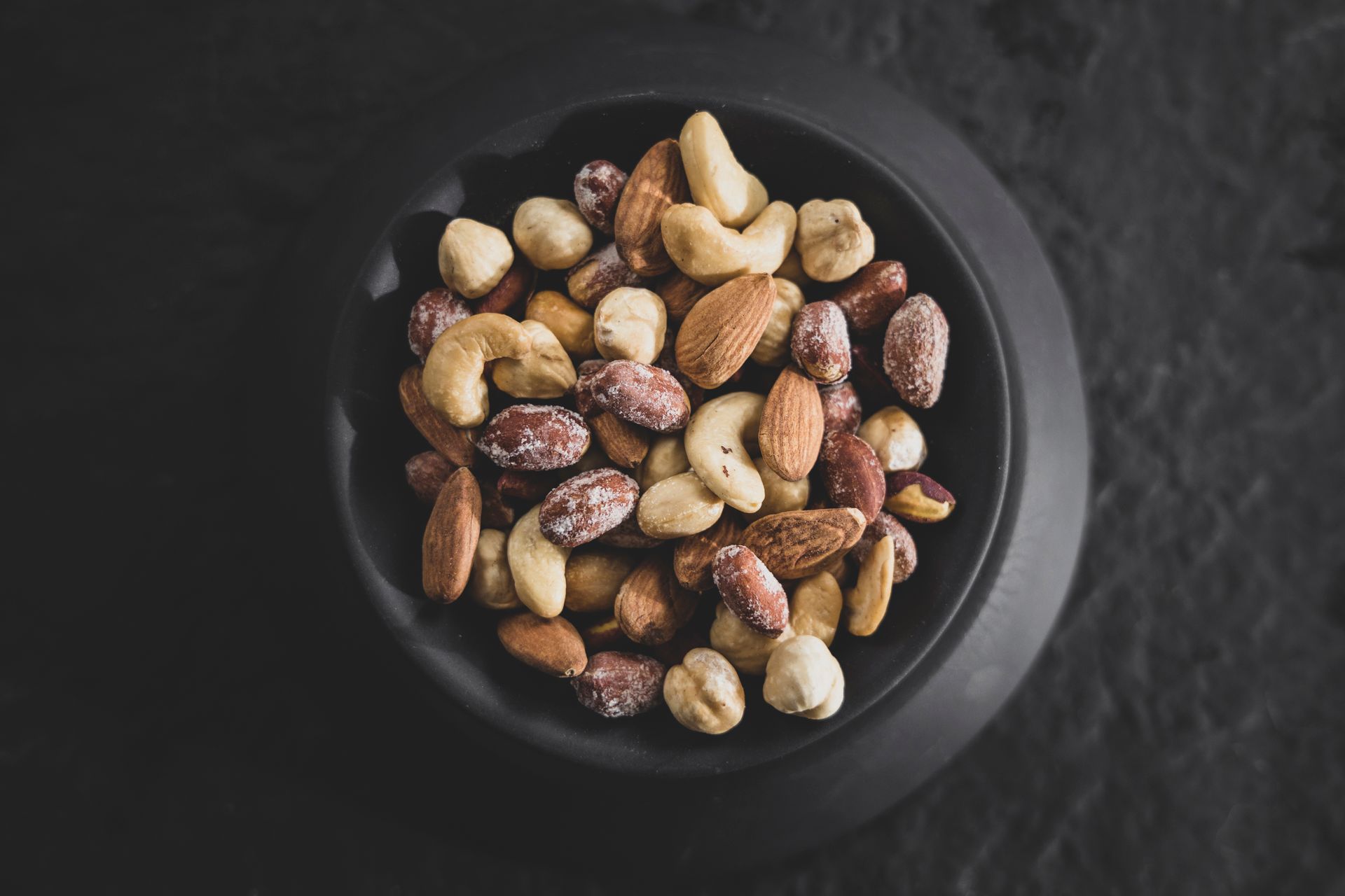 Sweet, salty and spicy party nuts in a black bowl