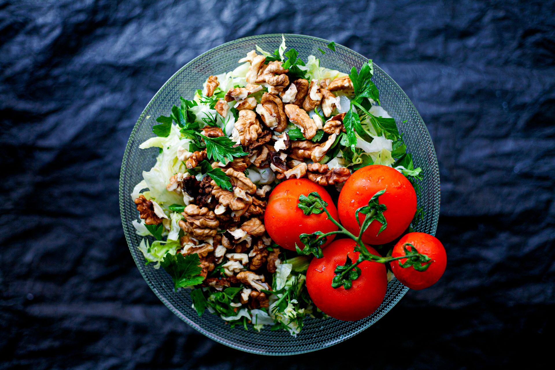 Green salad topped with sugared nuts and tomatoes