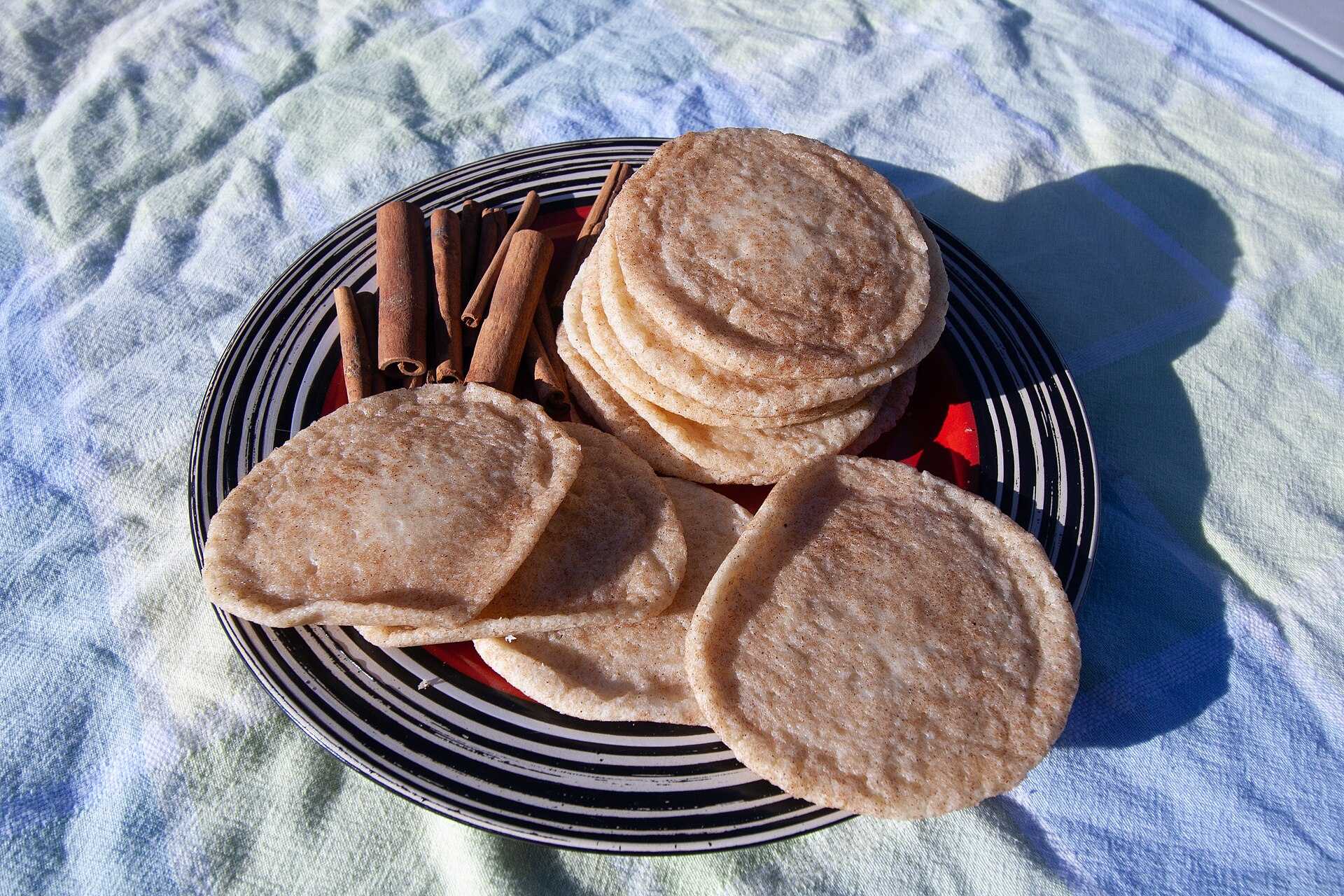 Chai-spiced snickerdoodles on a plate with cinnamon sticks
