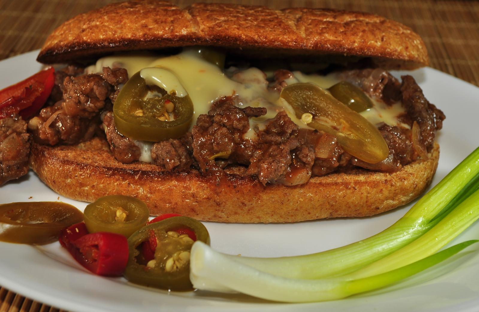 Ground beef hoagie with white queso, jalapenos and green onions