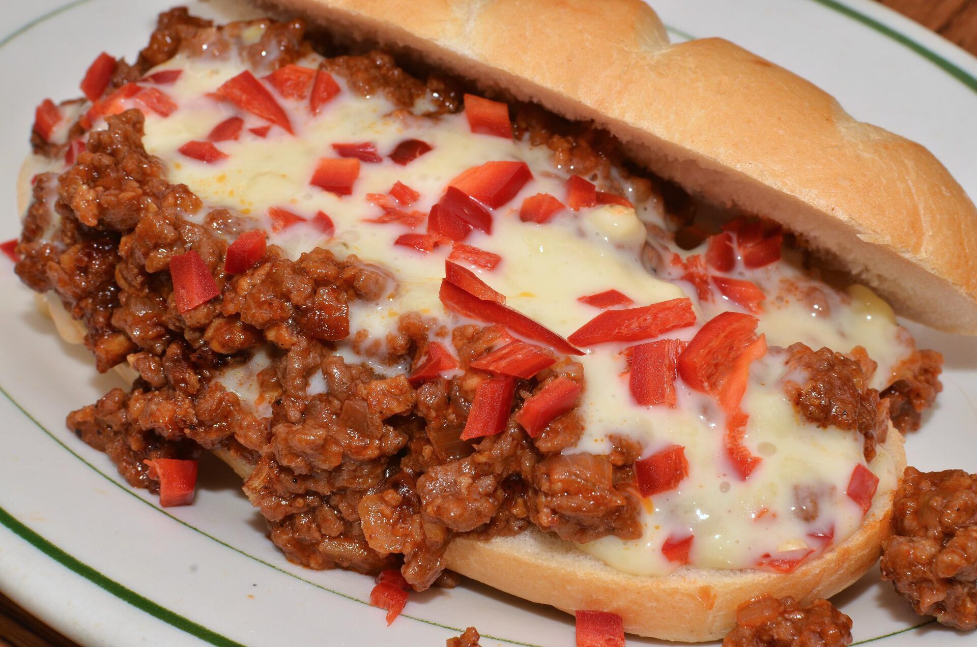 Open faced sloppy joes with melted cheese and red chilies