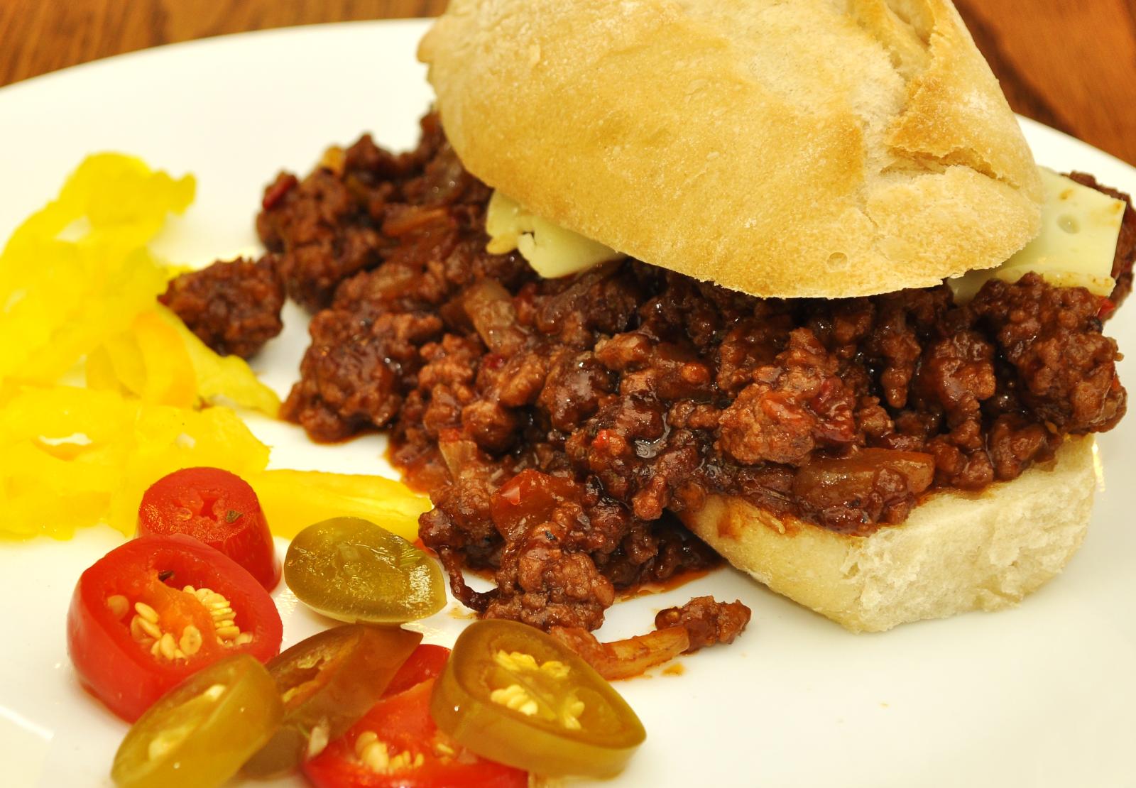 Sloppy joes on a bun with pickled peppers and banana peppers