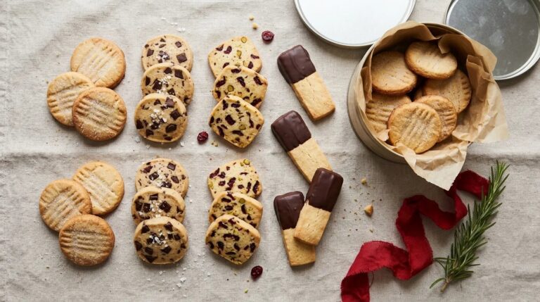 Christmas shortbread cookies flat lay with a cookie tin, rosemary and red ribbon