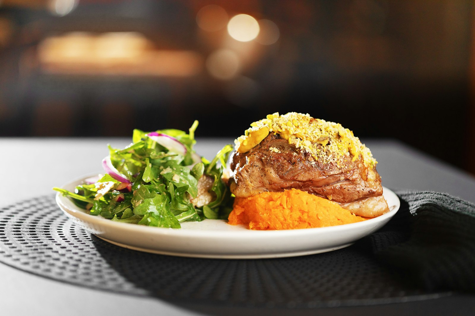 Dinner plate with a glazed slice, salad and potatoes