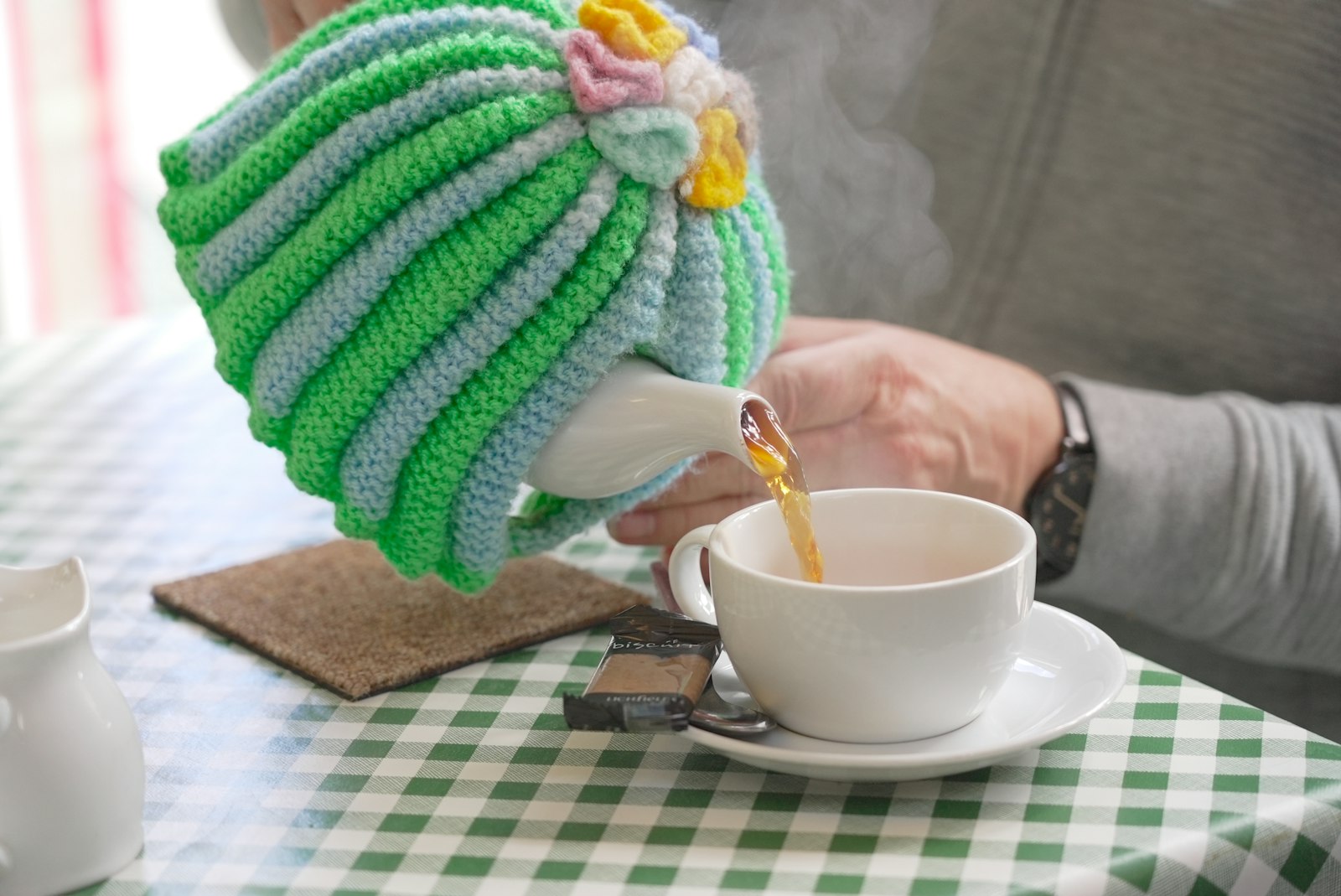 Pouring a medium strength cup of tea from a teapot