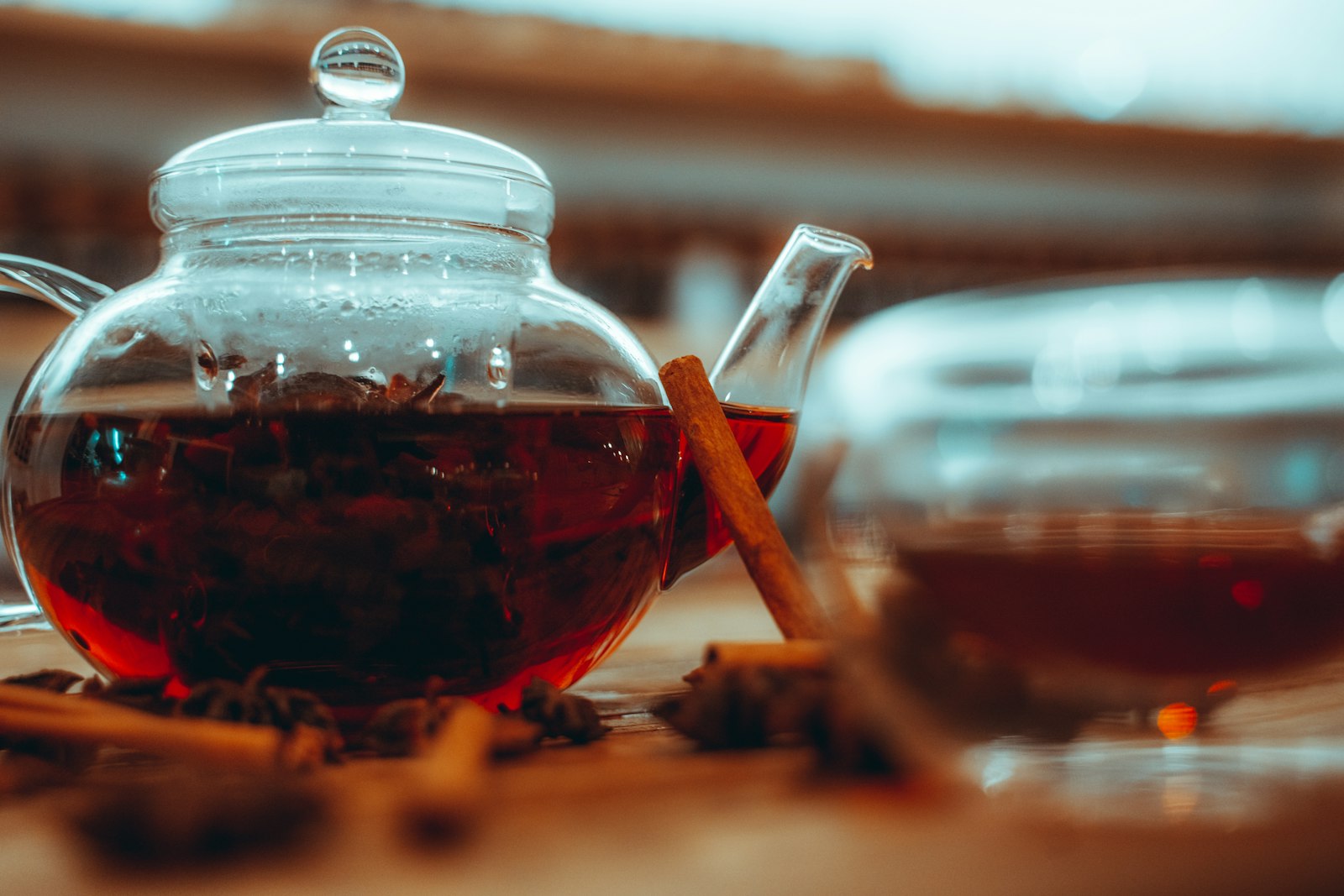 Glass teapot of warm spiced black tea with cinnamon