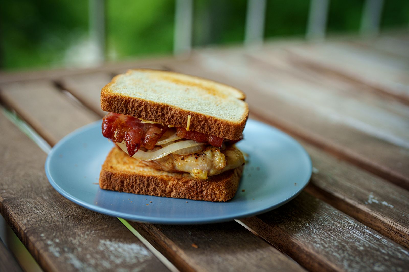 Toasted sandwich with bacon on a blue plate