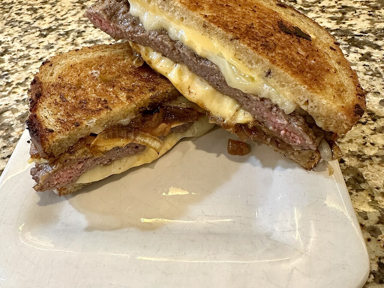 Patty melt cut open on rye bread