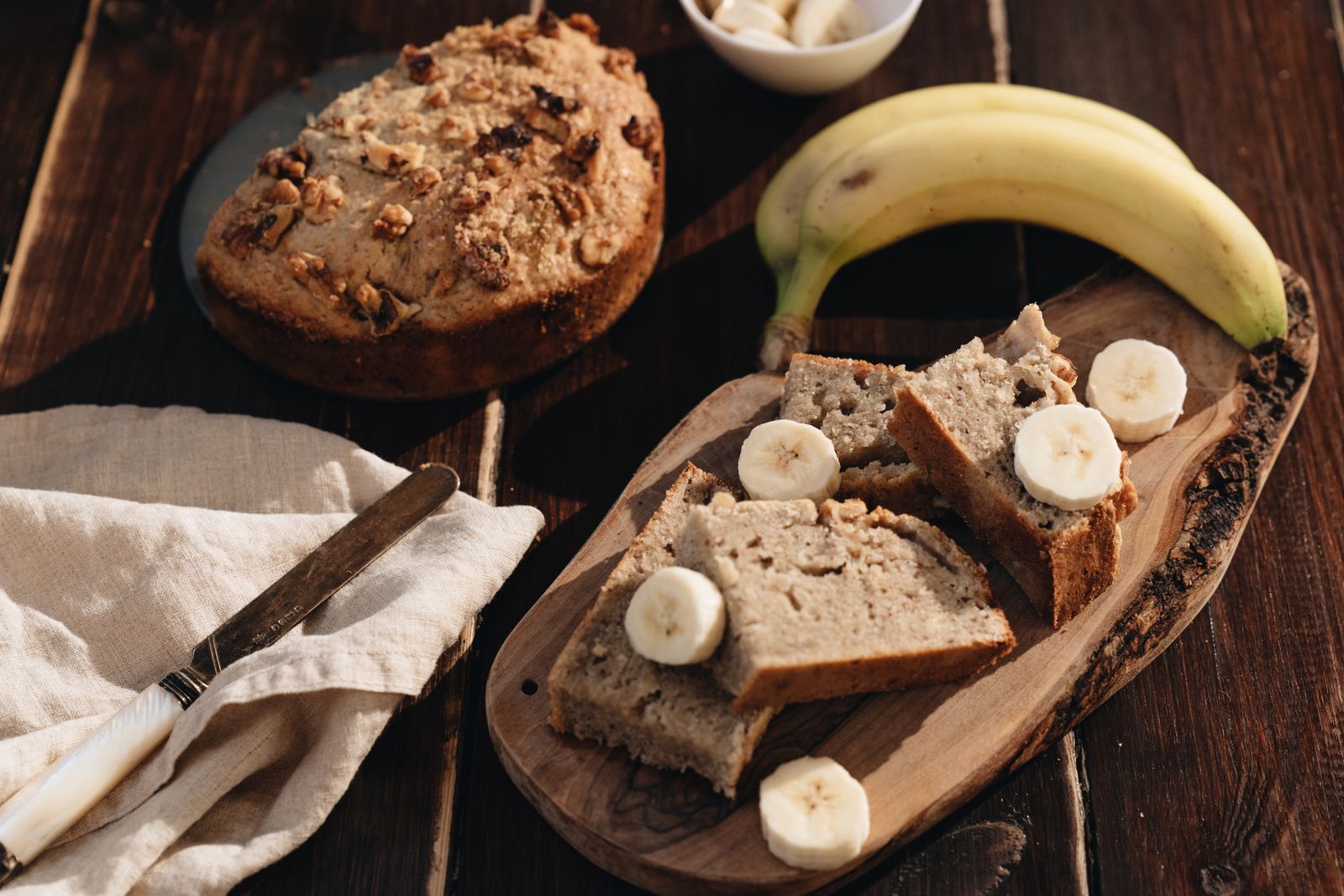 Homemade banana bread next to ripe bananas