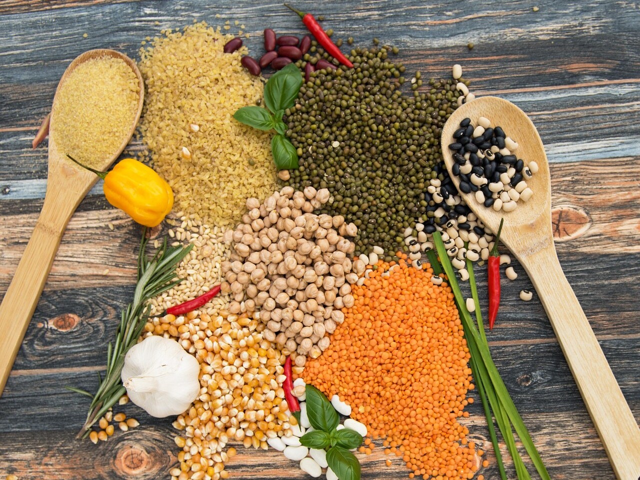 Dried beans, lentils and chickpeas on wooden spoons