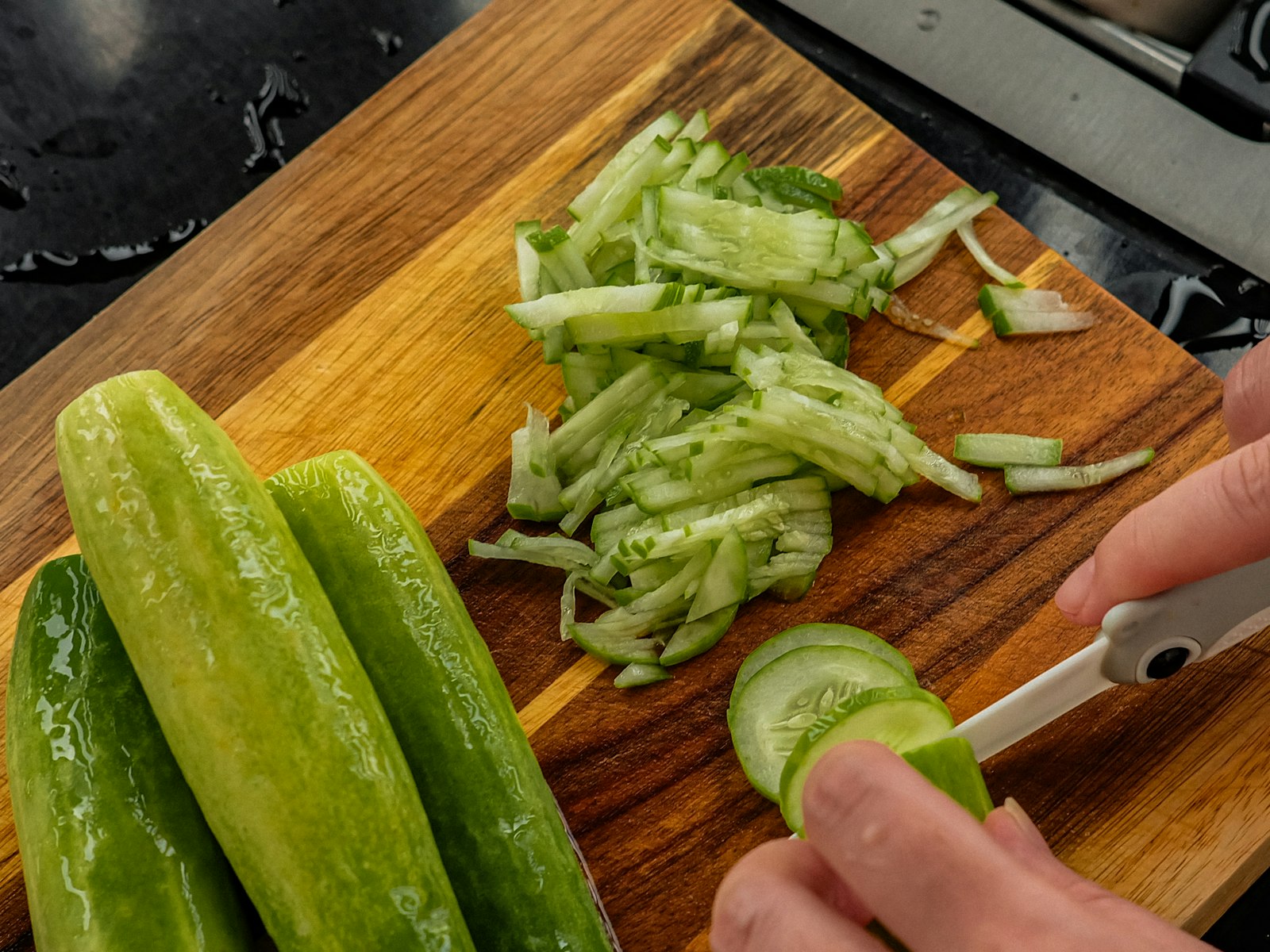 Slicing fresh cucumbers thin for a salad
