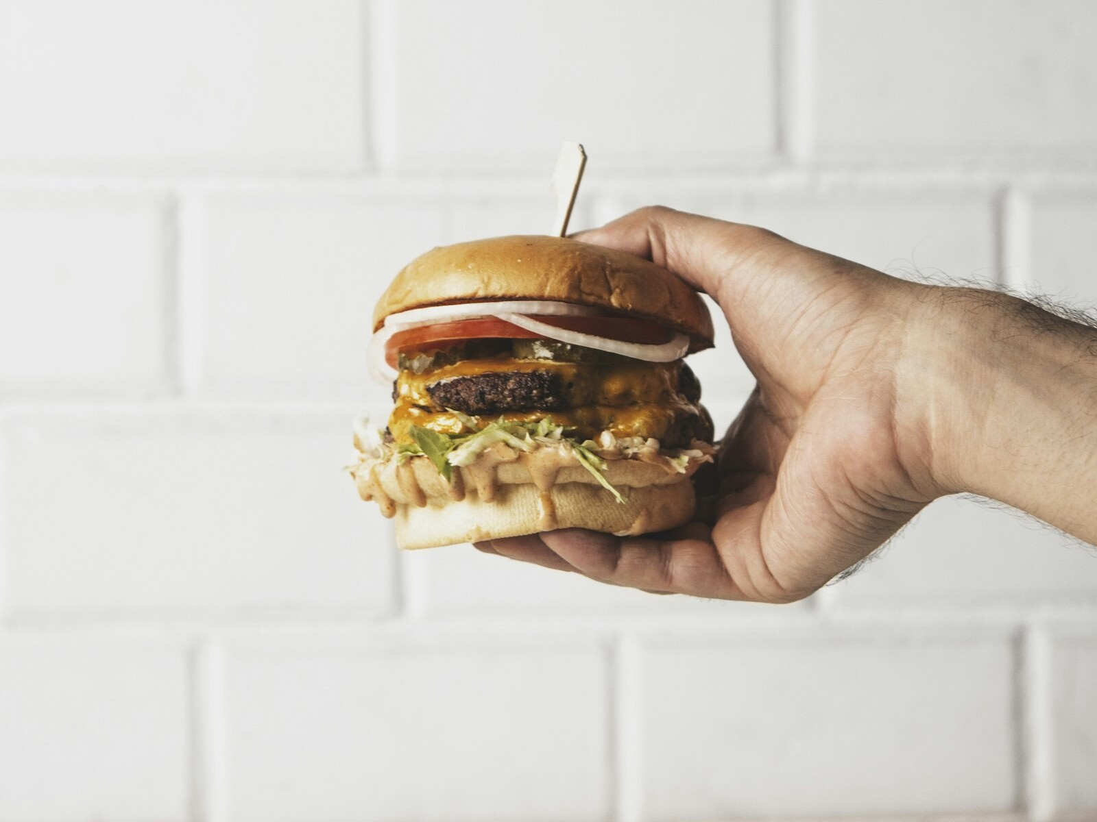 Eating a juicy burger held in one hand