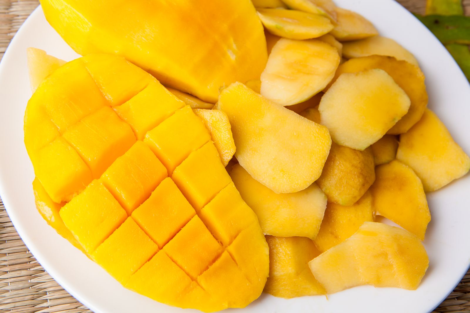 Eating a mango cut into a hedgehog with cubes ready to pop off
