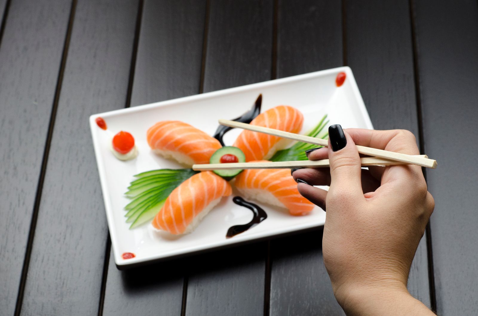 Eating salmon nigiri with chopsticks