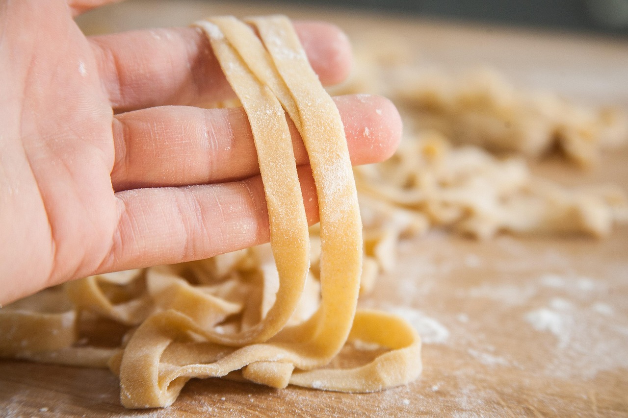 Hand holding freshly cut pasta strips