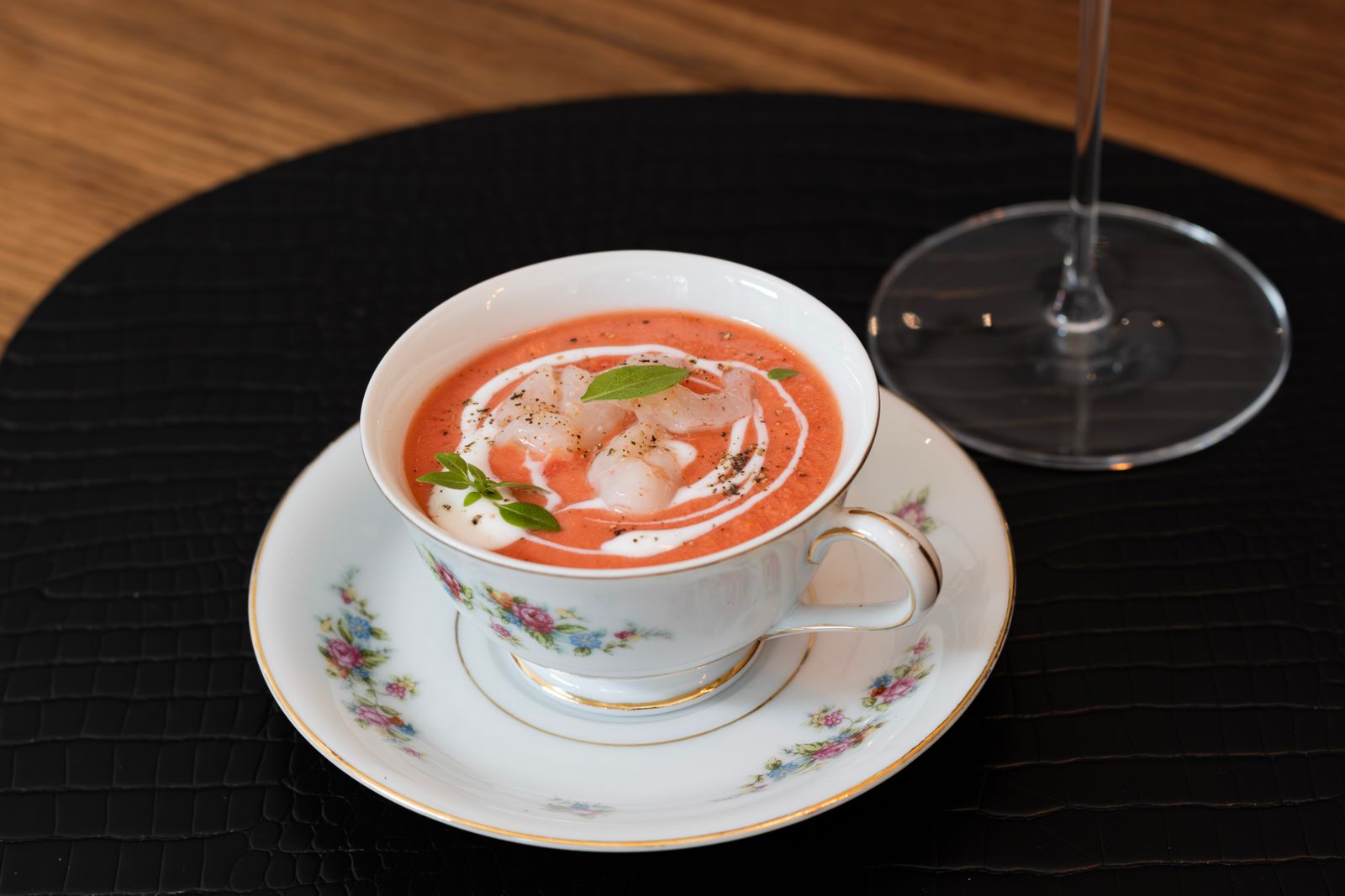 Velvety bisque in a teacup with a swirl of cream