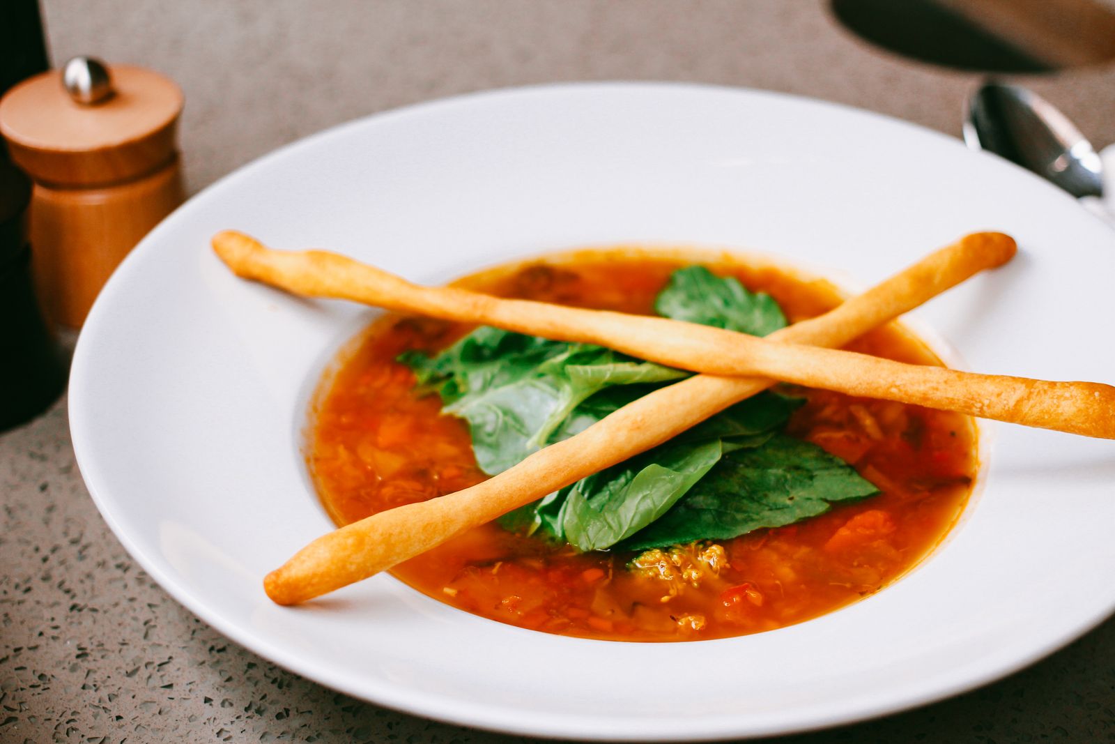Spinach and pasta bowl with breadsticks