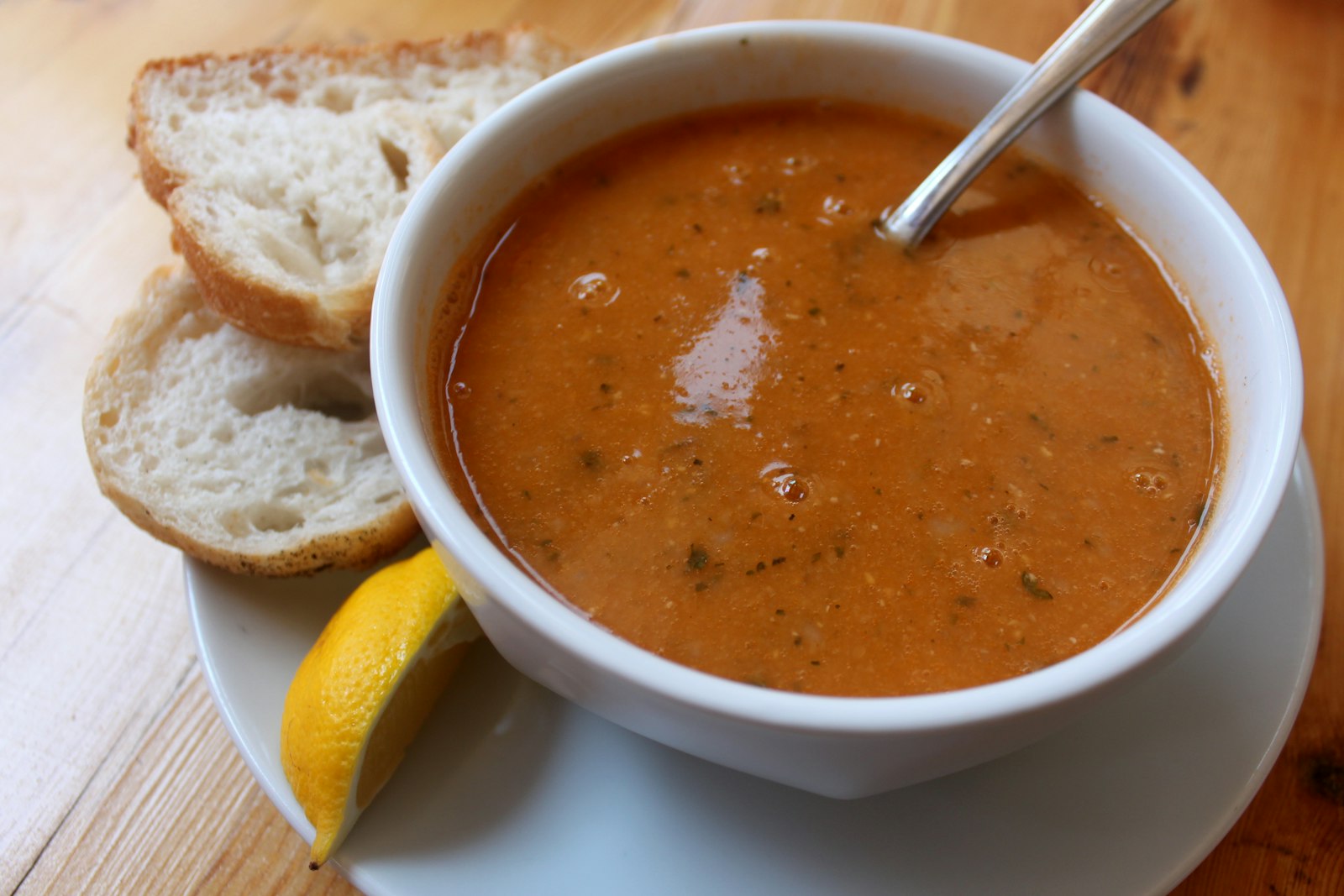 Red lentil bowl with crusty bread and lemon