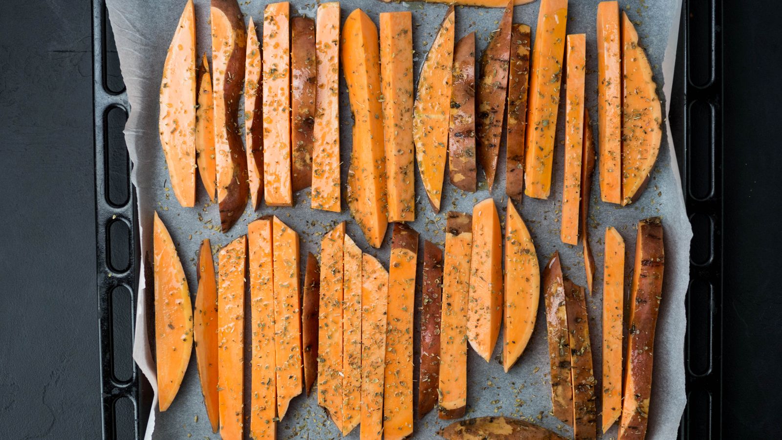 Seasoned sweet potato wedges on a baking tray