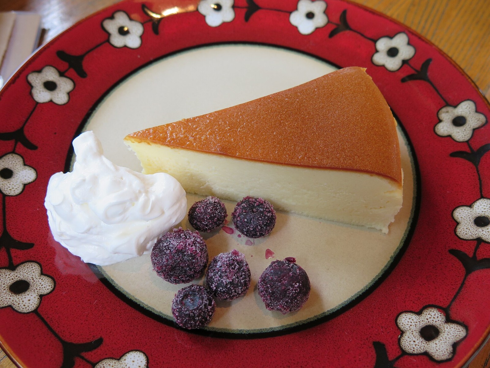 Slice of creamy cheesecake with whipped cream and berries