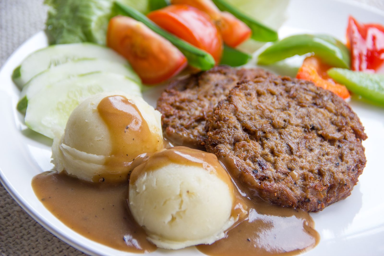 Hamburger patty with mashed potatoes and brown gravy