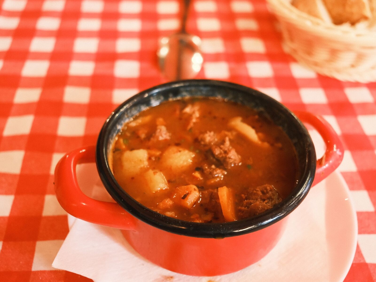 A pot of tomato stew on a checkered cloth, like Depression era Hoover stew