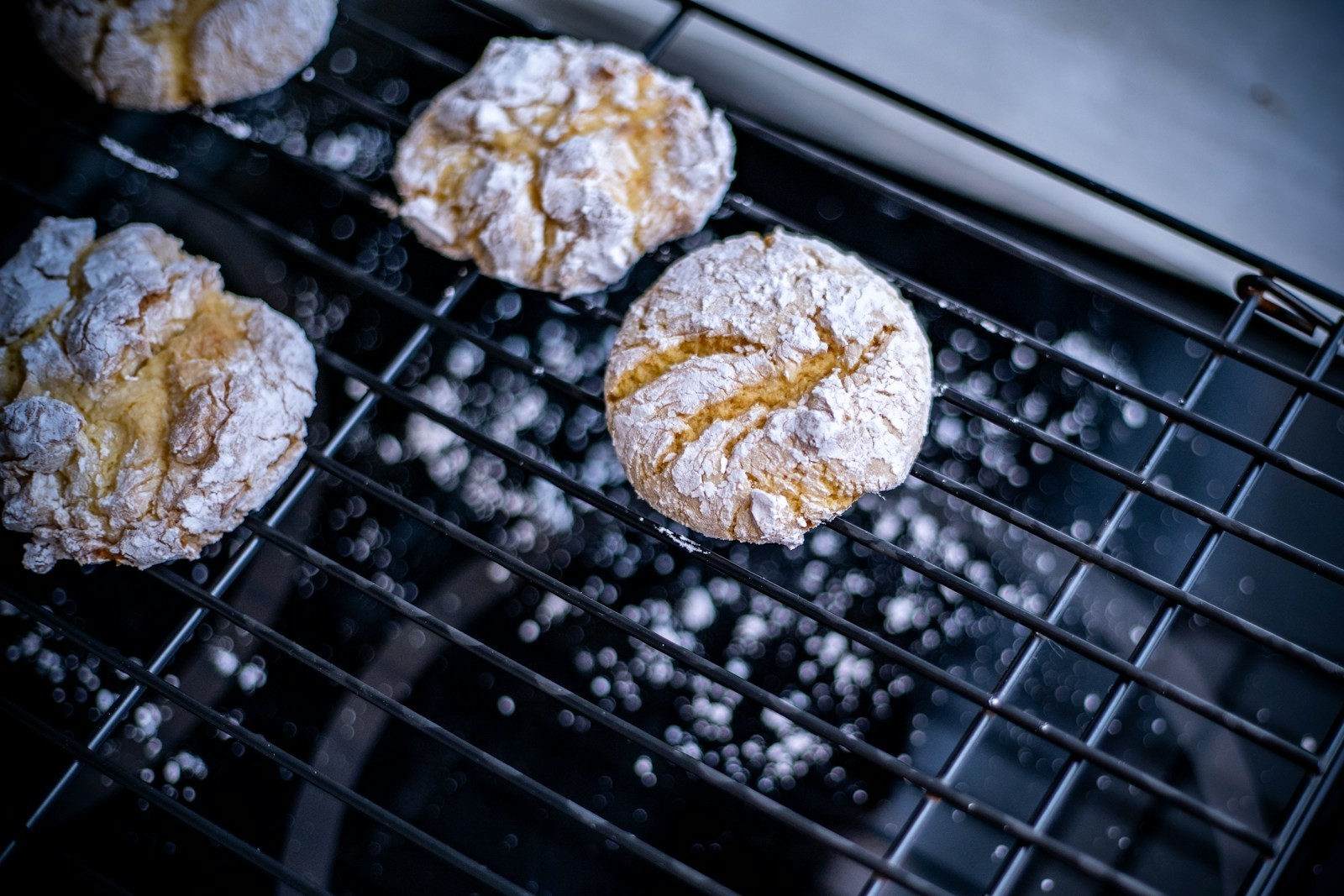 Classic gooey butter cookies with crackled powdered sugar tops cooling on a wire rack