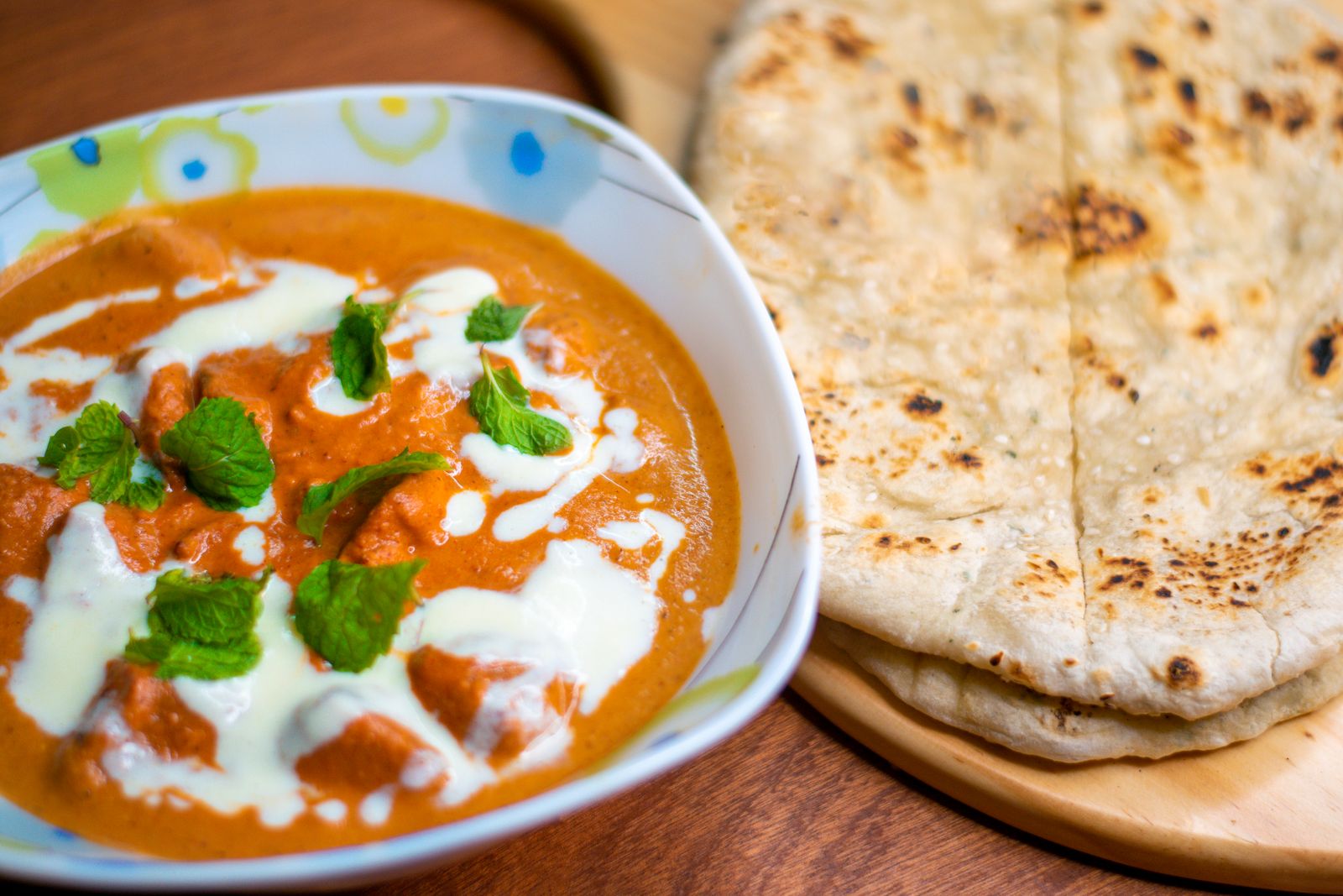 Butter chicken in a creamy tomato sauce with naan bread