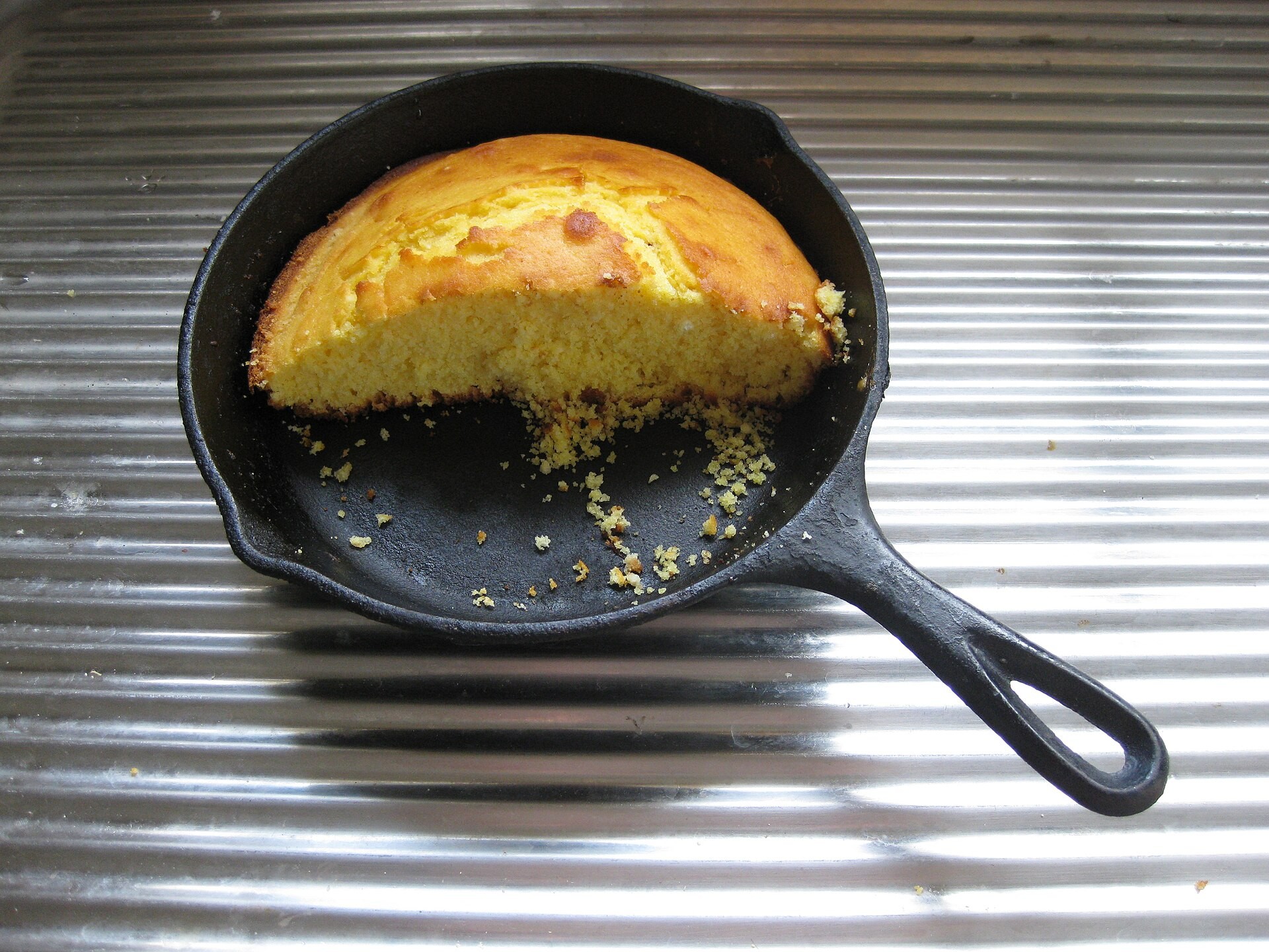 Golden cornbread baked in a small cast iron skillet
