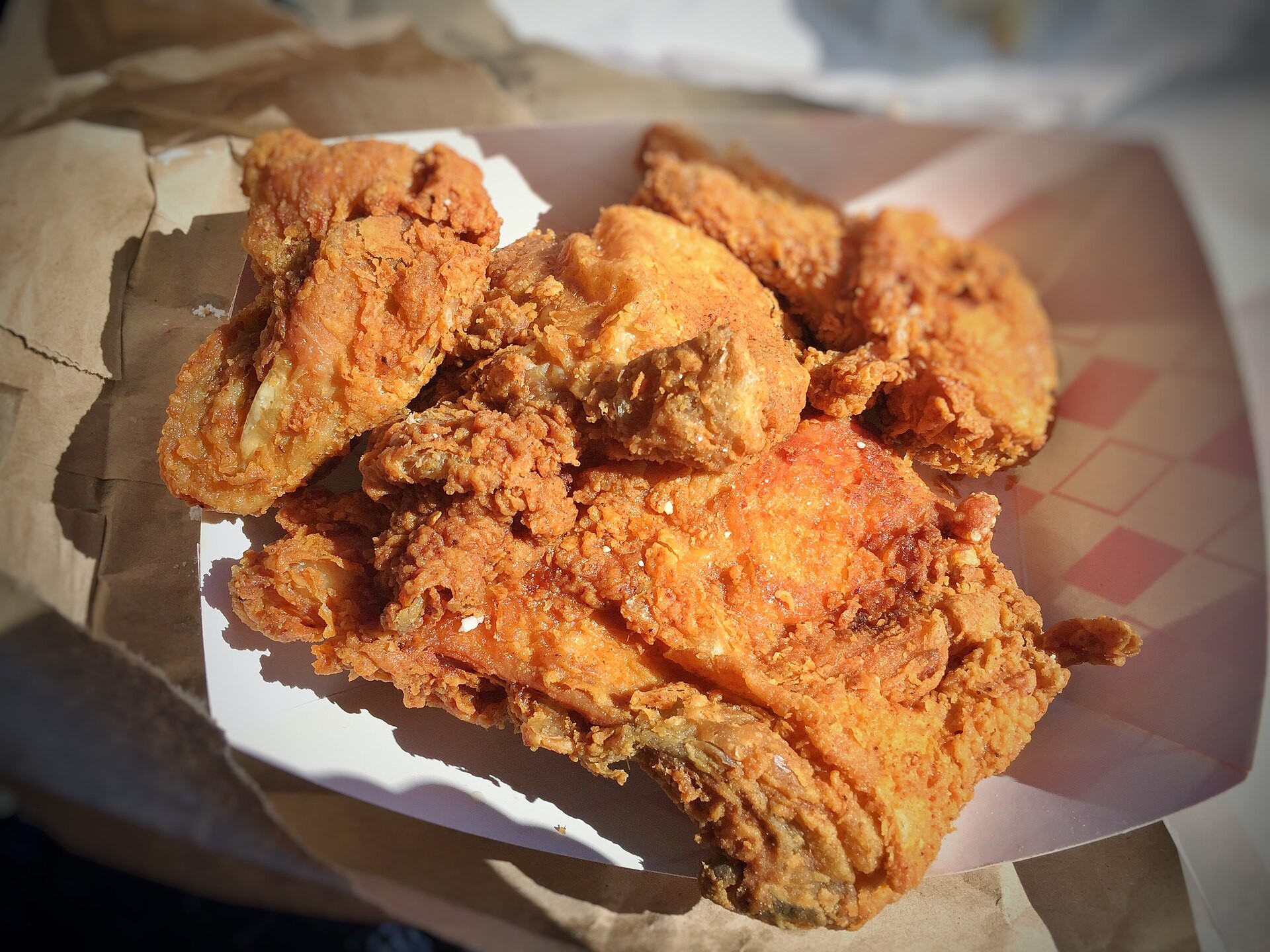 Golden crispy Southern fried chicken pieces in a paper-lined basket
