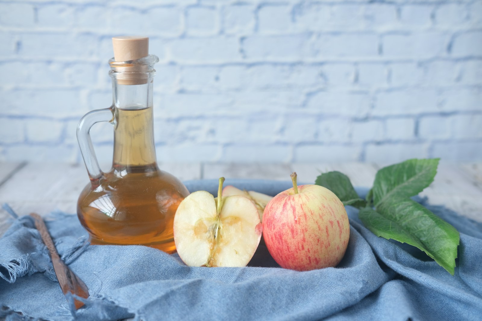 Bottle of apple cider next to fresh apples
