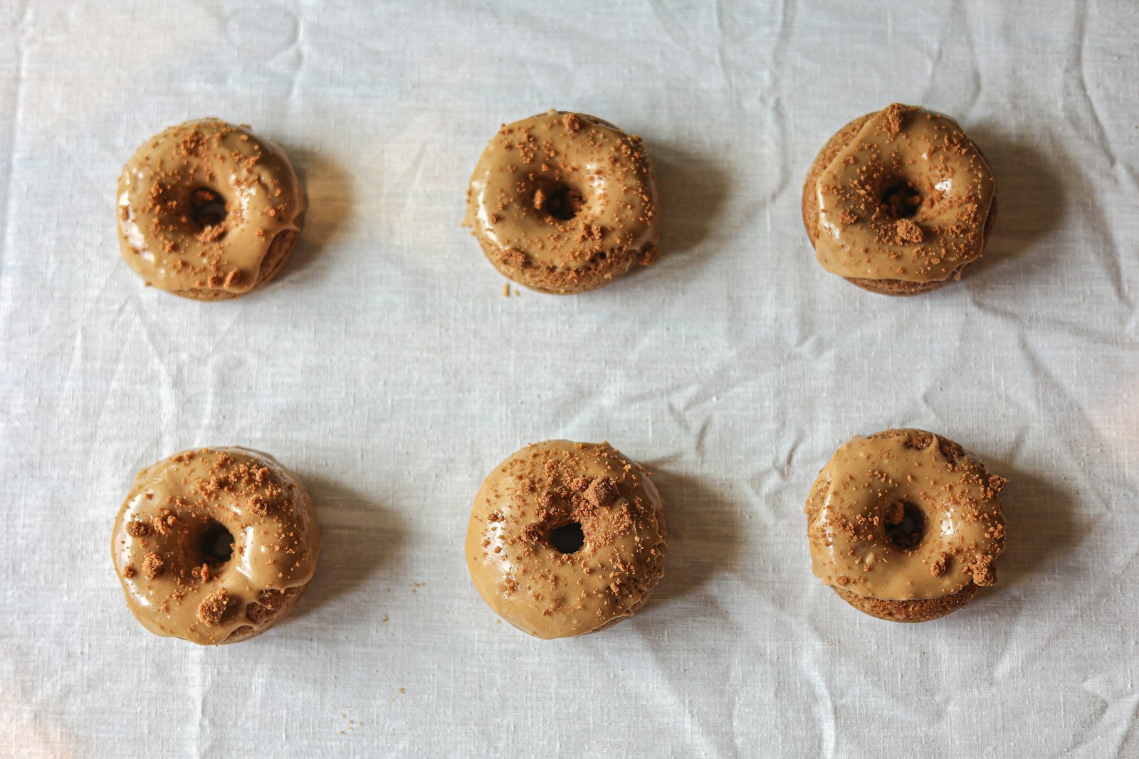 Baked apple cider donuts cooling on parchment