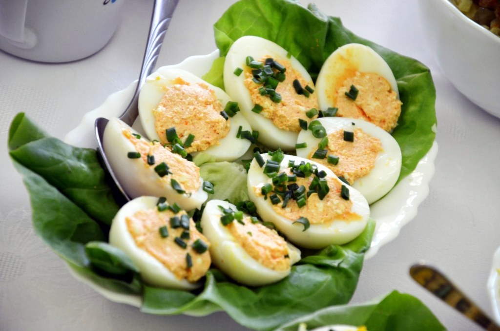 Deviled eggs topped with chives on lettuce leaves