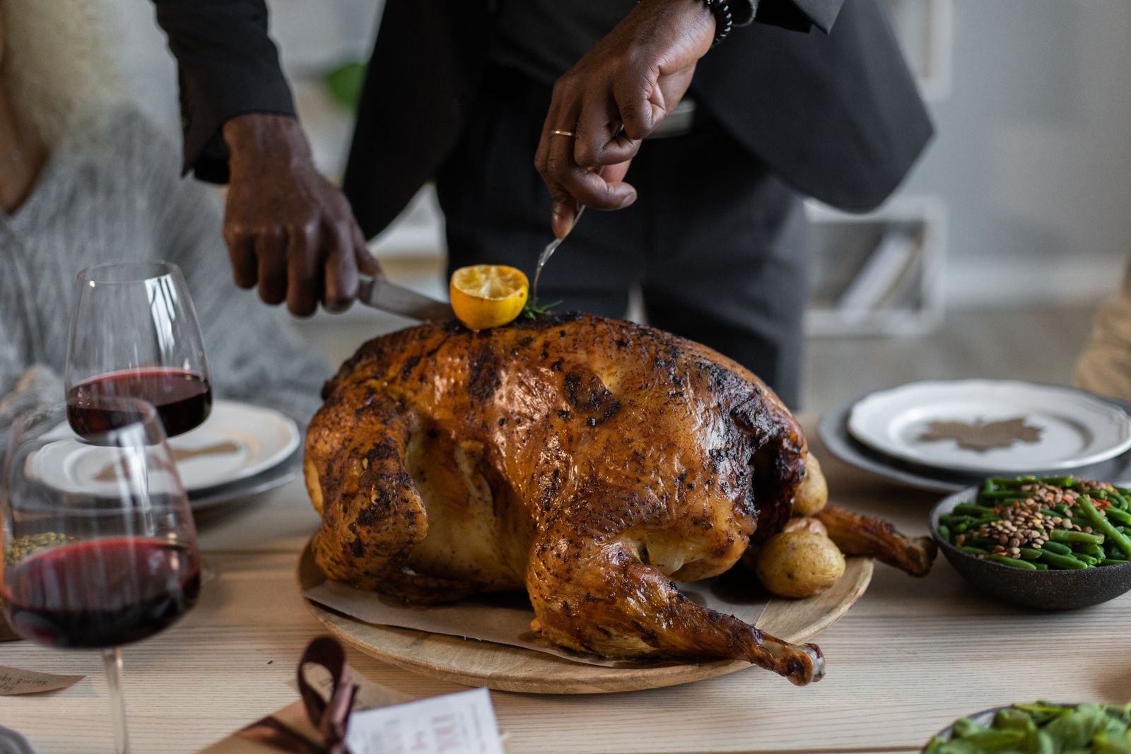 Thanksgiving foods: a roasted turkey being carved at the table