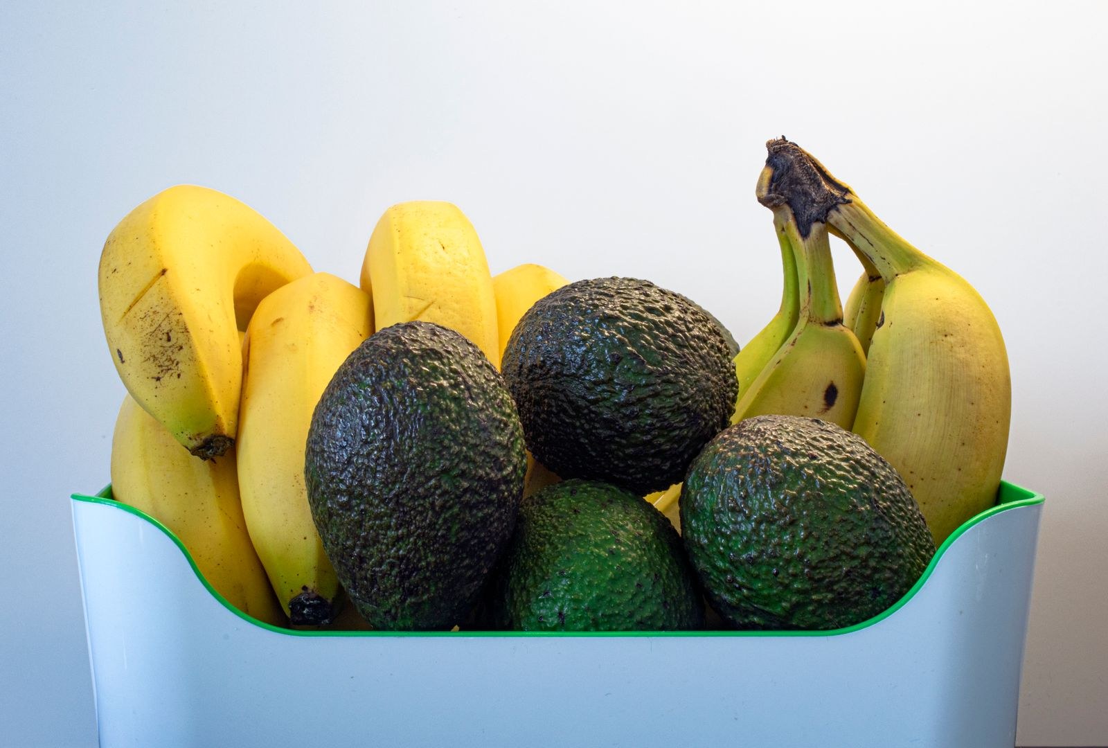 Avocados ripening next to bananas