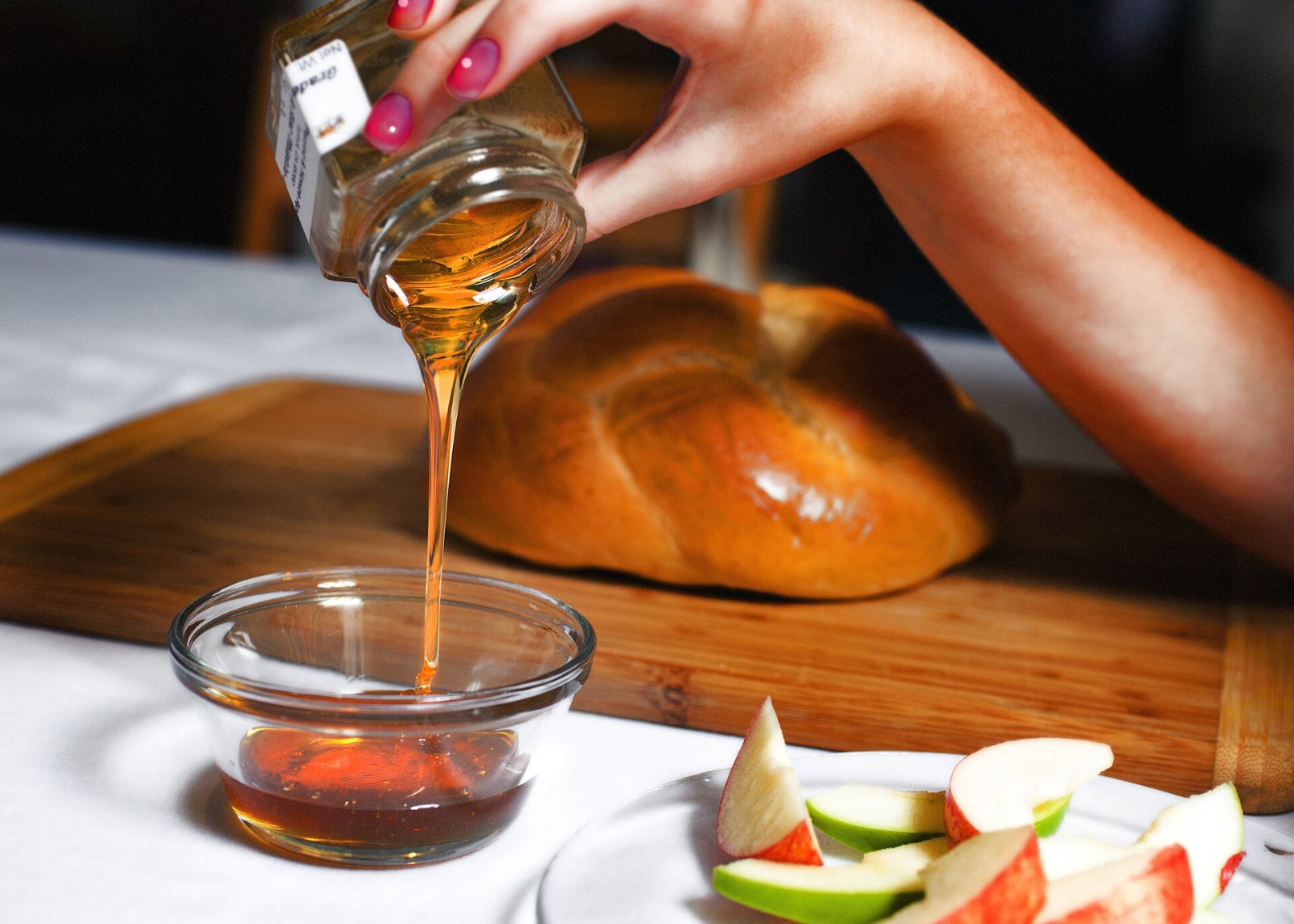Honey drizzling from a spoon into a small glass