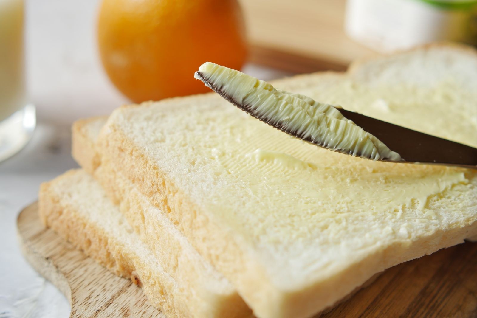 Spreading soft butter on slices of bread