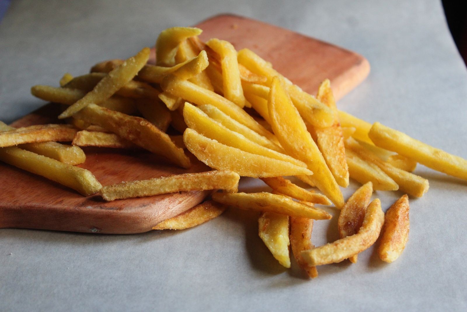Homemade french fries on a wooden board