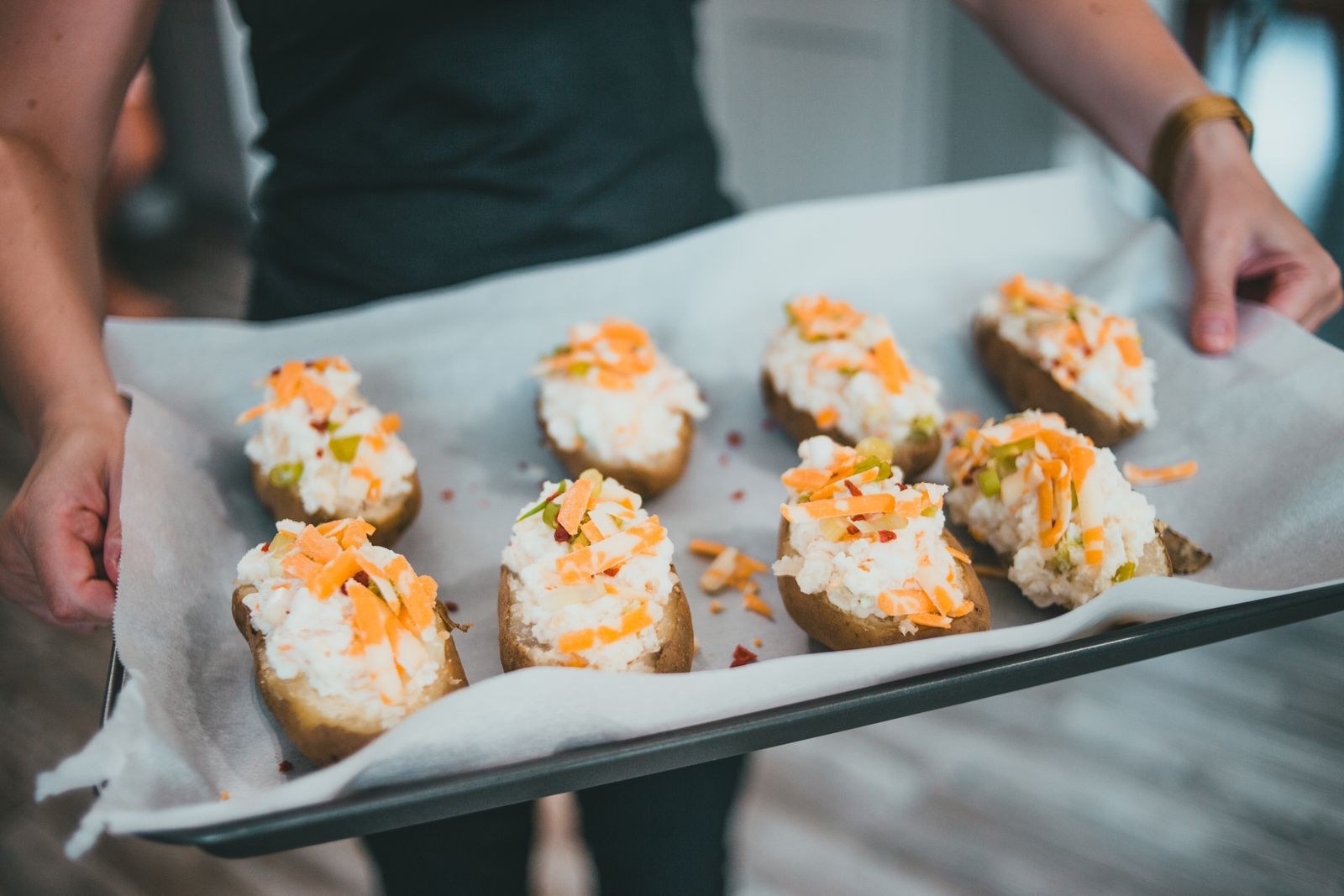 Baked potatoes with toppings on a baking tray