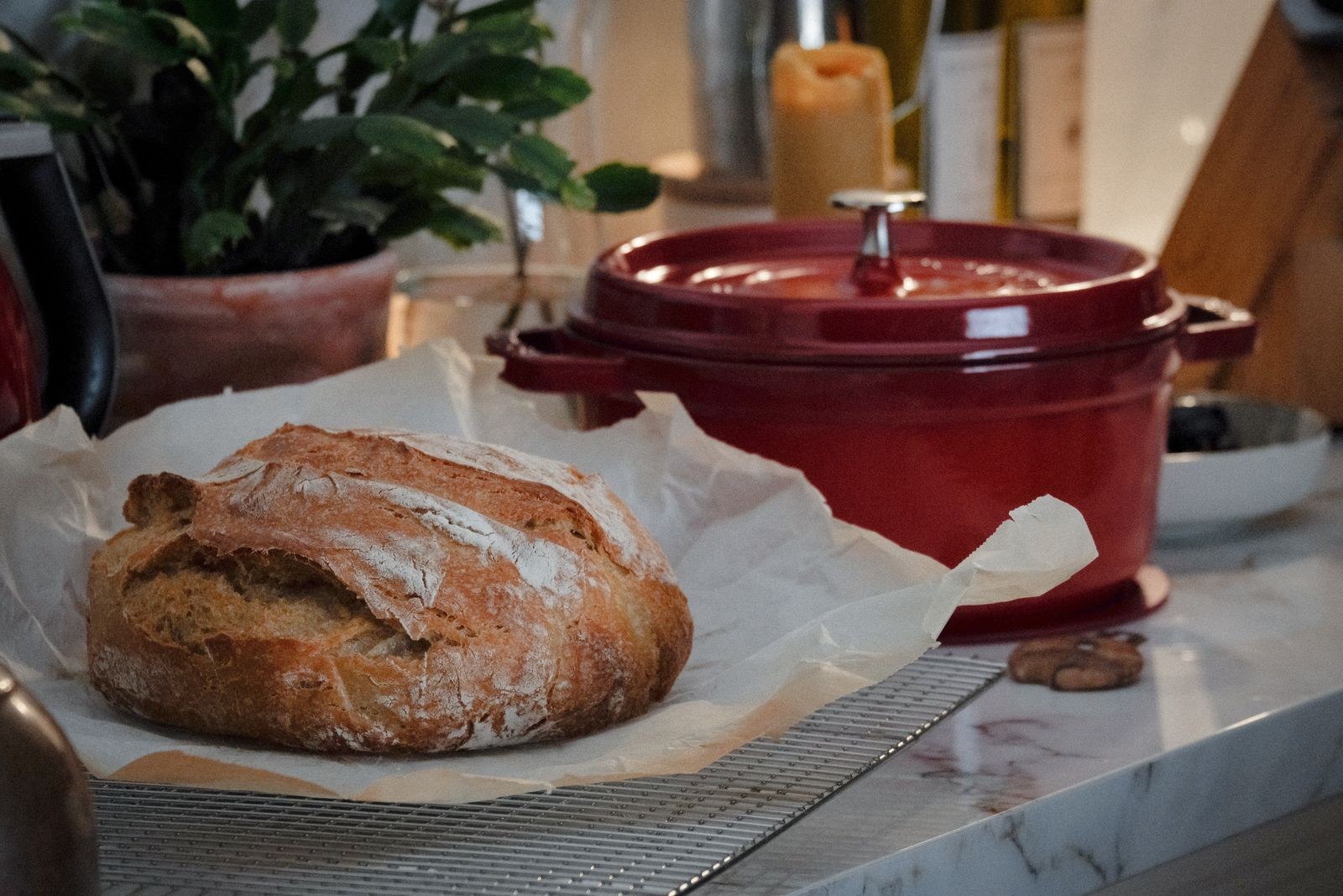 Dutch oven recipes: a crusty loaf of no-knead bread next to a red Dutch oven
