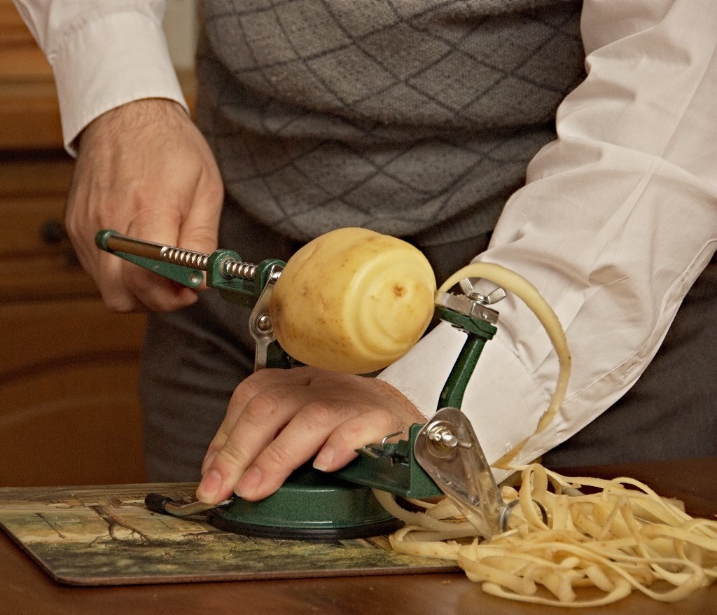 Vintage kitchen gadgets: a hand-crank peeler at work