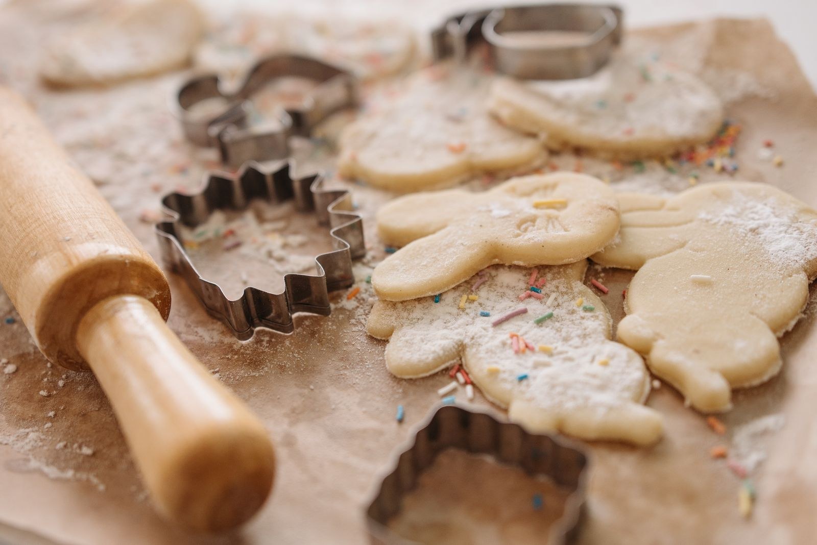 Vintage kitchen gadgets: a wooden rolling pin and cookie cutters with sugar cookies