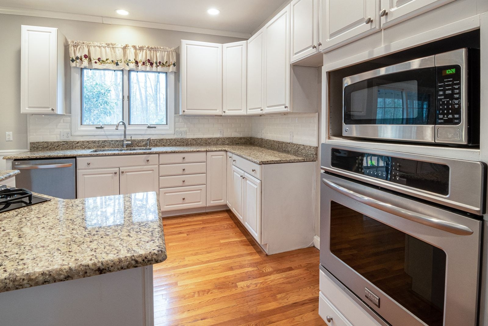 A kitchen with a built-in microwave